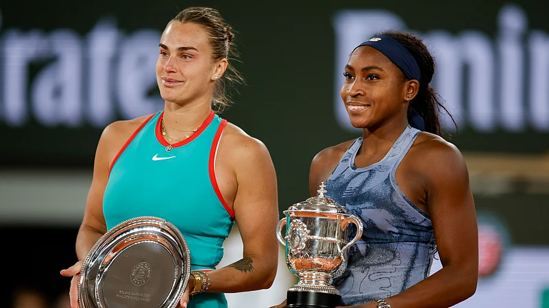 Coco and Aryna are holding trophies.